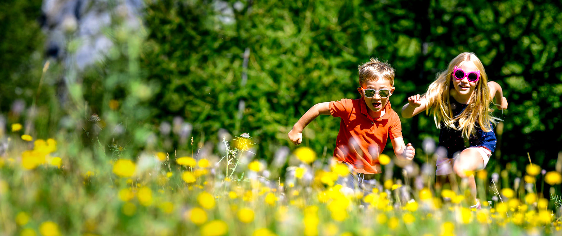 2 kids running in a field of flowers 